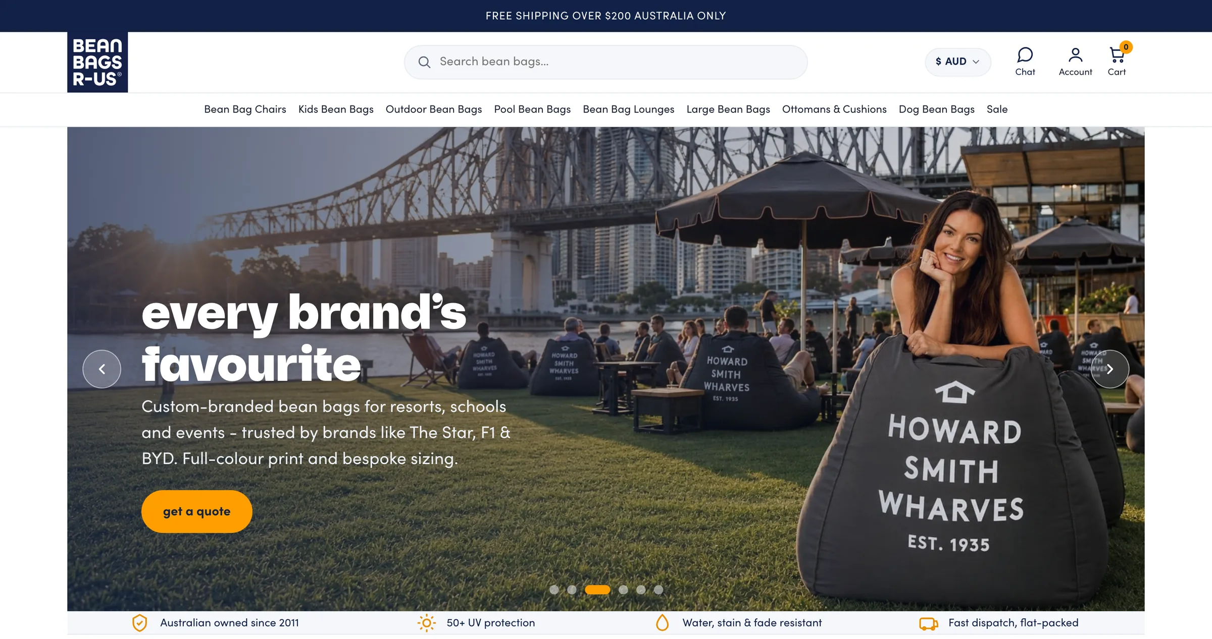 Bean Bags R Us homepage on desktop: the navy BEAN BAGS R-US logo, a search bar, an AUD currency selector and a menu of ranges from Bean Bag Chairs to Dog Bean Bags, above a banner reading 'every brand's favourite' with branded bean bags on a riverside lawn under a city bridge