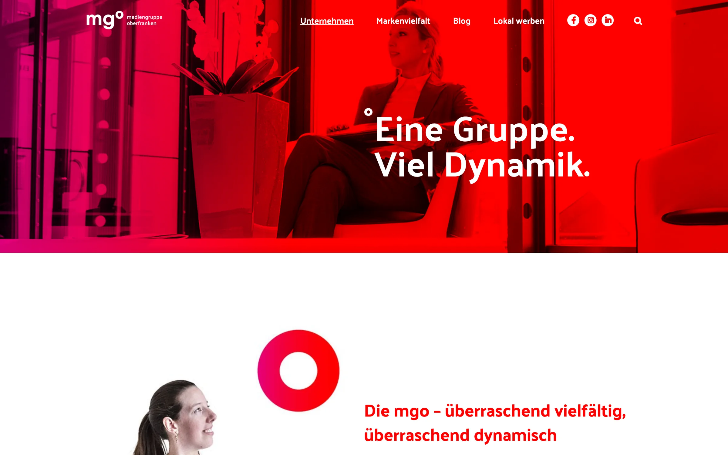 The company page: a red-toned photograph of an office under the headline 'Eine Gruppe. Viel Dynamik.'